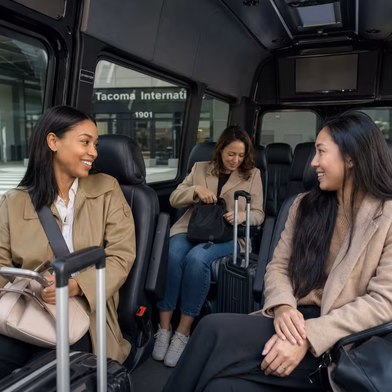 Passengers loading luggage while boarding an Tacoma group shuttle
