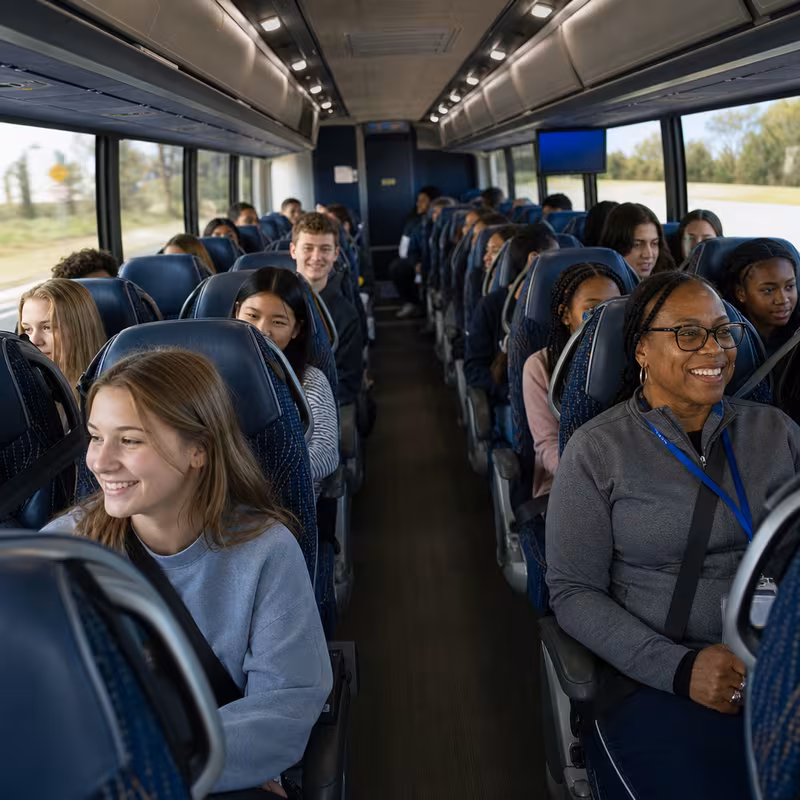 Group boarding a white charter bus for School Transportation transportation in Tacoma