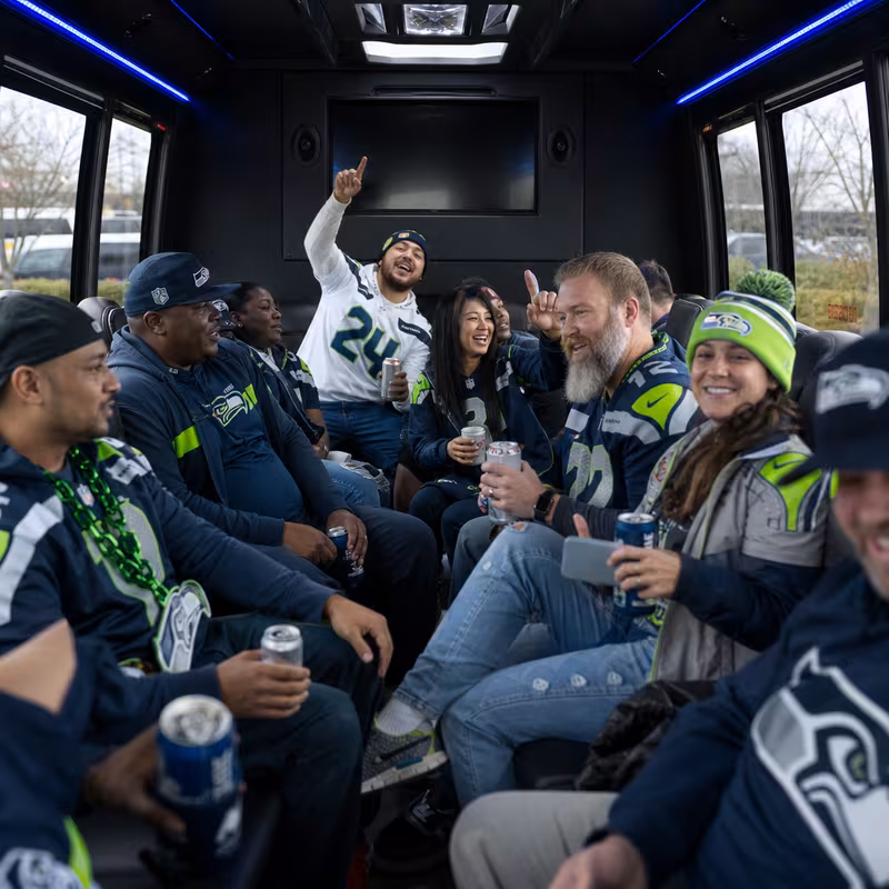 Group boarding a white charter bus for Sporting Event Transportation transportation in Tacoma