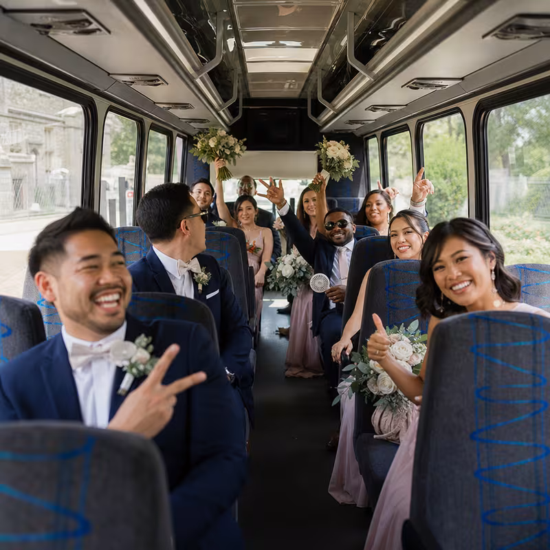 Group boarding a white charter bus for Wedding Transportation transportation in Tacoma